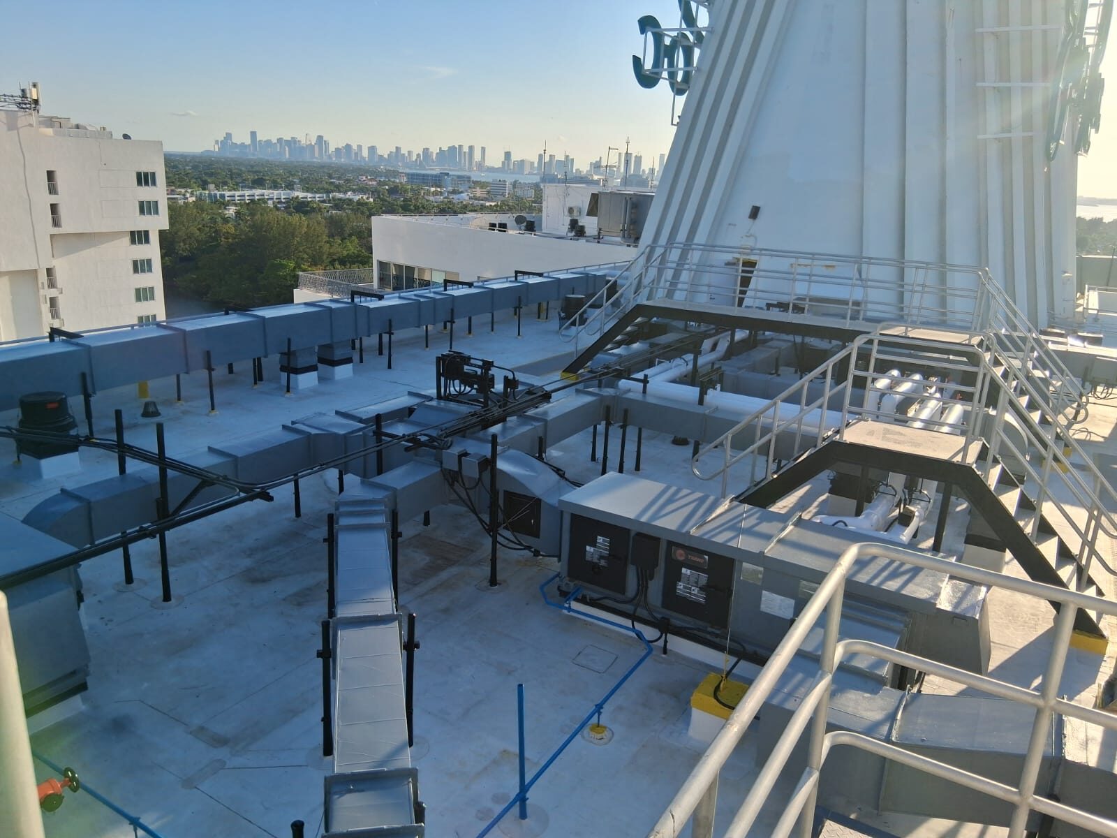 Rooftop mechanical piping runs with city skyline