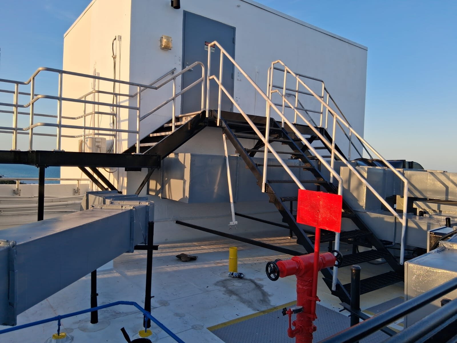 Rooftop access platform and stairs with city skyline